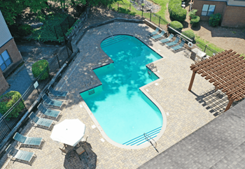 an aerial view of a swimming pool and patio with chairs